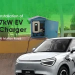 Silver electric vehicle charging at IKAN Engineering from a newly installed 7kW EV charger, securely housed in a light blue outdoor cabinet on Multan Road.